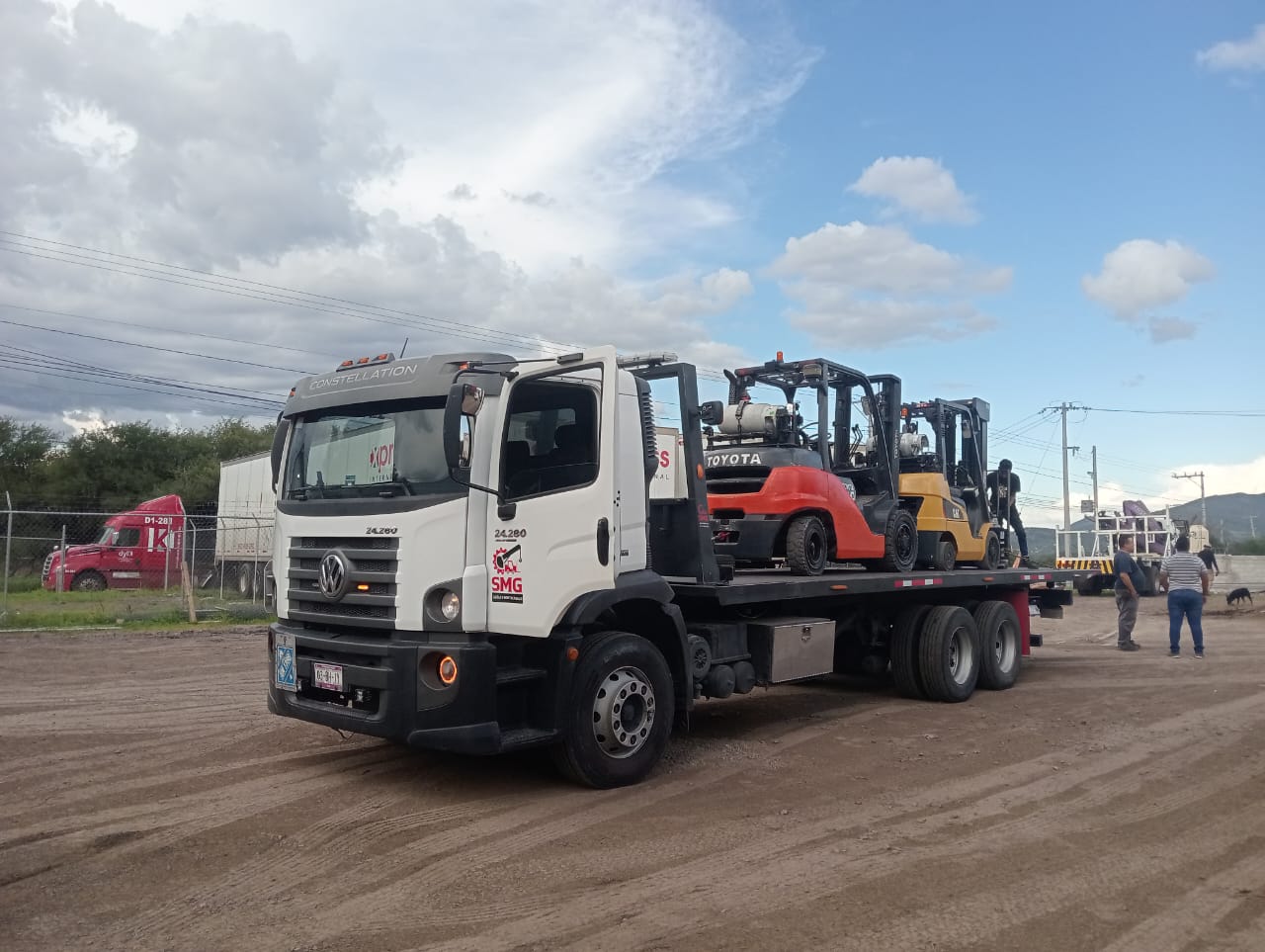 Camión plataforma de SMG transportando dos montacargas